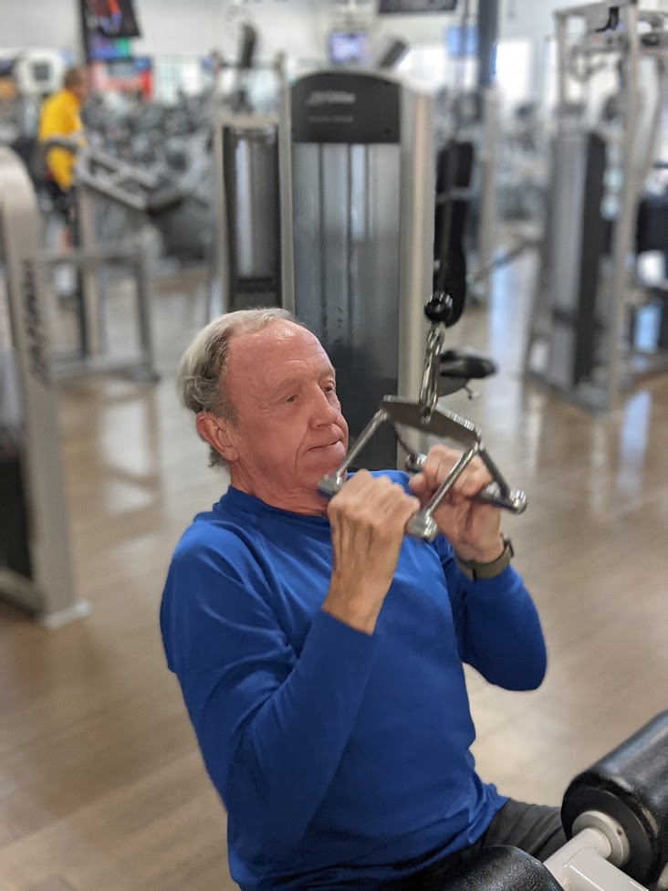 Older adult client doing lat pull downs